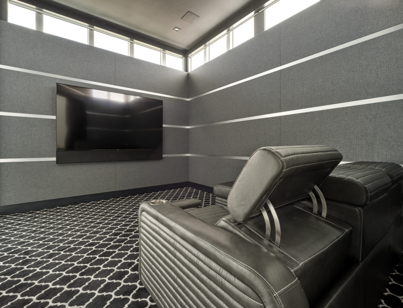 A home theater with two black reclining chairs
